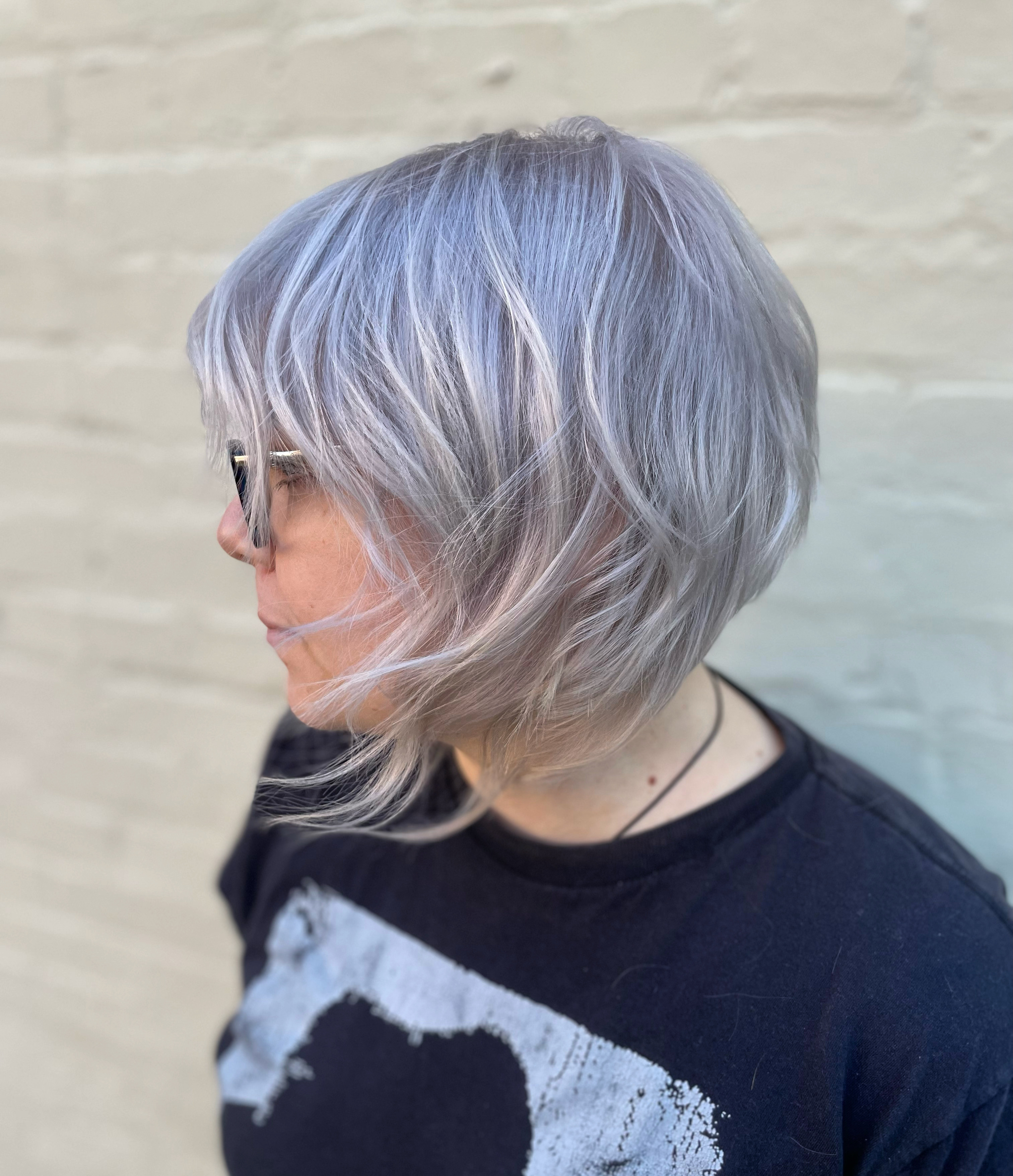 A client with a choppy, short hair cut and silvery white color