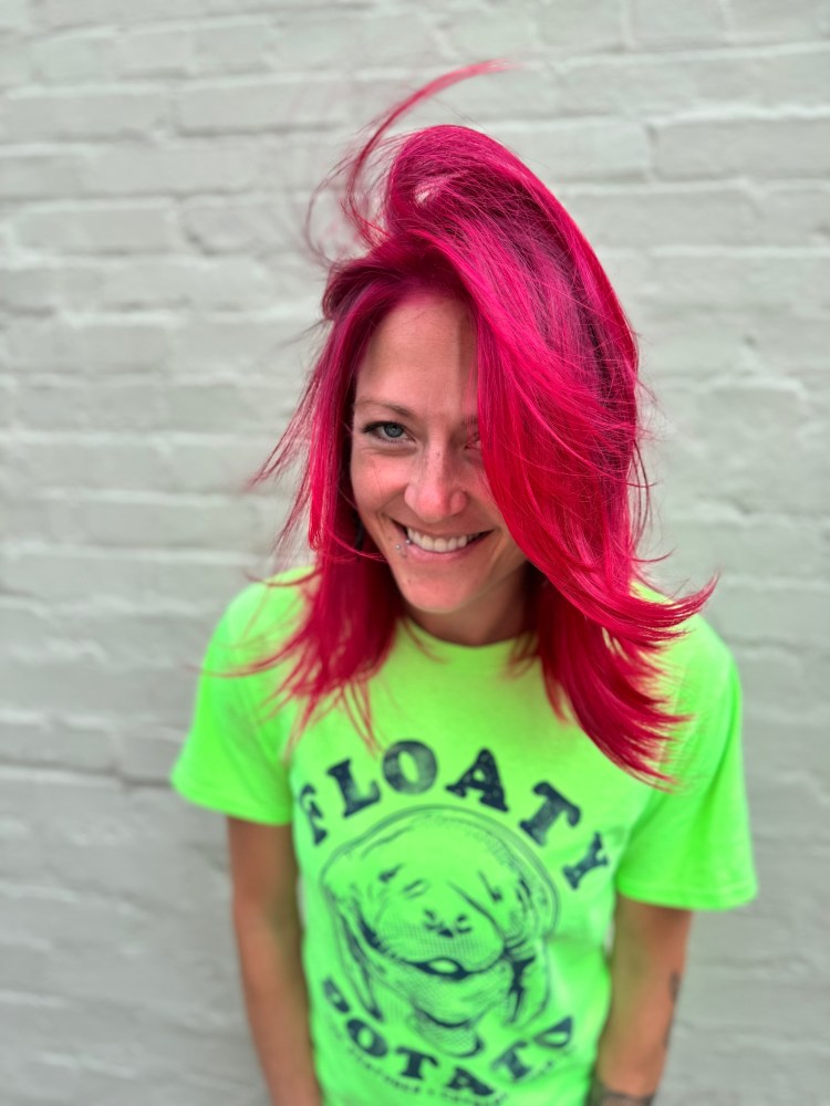 A smiling client with magenta pink hair