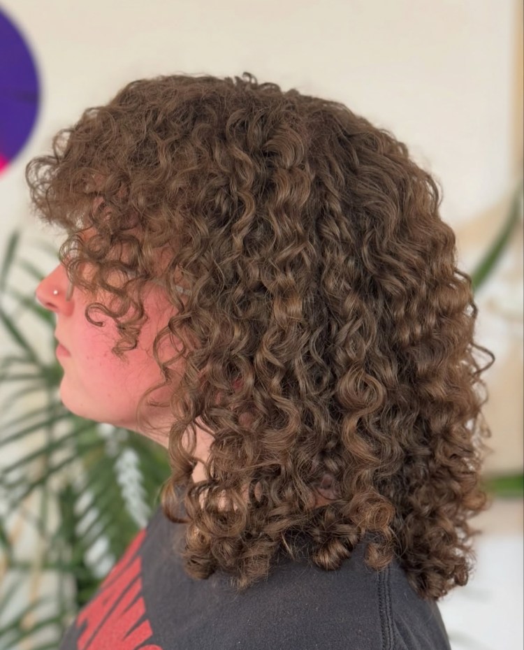 A client with shoulder-length brunette curls