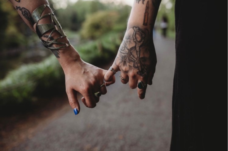 Two hands holding each other's pinkies.