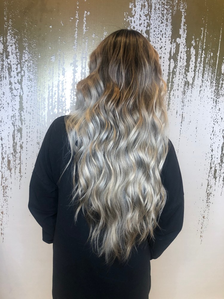 A client with a long, wavy blonde gradient cut